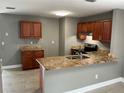 Kitchen features granite countertops, wood cabinets, stainless steel appliances, and a breakfast bar at 2078 Keyes Ln, Deltona, FL 32738