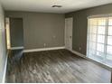 Spacious living room with hardwood floors, fresh paint, a white door, and multiple windows at 2078 Keyes Ln, Deltona, FL 32738