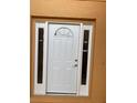 Close-up of a white front door, with sidelights and a half-round window at 2299 Rock Dr, Poinciana, FL 34759