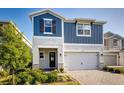 Charming two-story home featuring a two-car garage, a brick driveway, and manicured landscaping at 2354 Emerald Springs Dr, Apopka, FL 32712