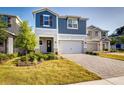 Charming two-story home featuring a two-car garage, a brick driveway, and a well-maintained lawn at 2354 Emerald Springs Dr, Apopka, FL 32712