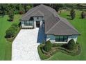 Stunning aerial view of a home with a paver driveway, manicured lawn, and elegant landscaping at 25974 High Hampton Cir, Sorrento, FL 32776