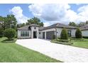 Beautiful home featuring a three-car garage, well-maintained landscaping, and a stylish gray and white color scheme at 25974 High Hampton Cir, Sorrento, FL 32776
