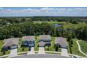 Aerial view of well maintained homes and a beautiful green landscape with a small pond at 3759 Crimson Clover Dr, Mount Dora, FL 32757