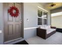 Cozy covered front porch with outdoor seating and a lovely decorative wreath on the door at 3759 Crimson Clover Dr, Mount Dora, FL 32757