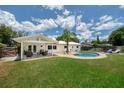Private backyard featuring a sparkling pool, patio seating, and lush green lawn perfect for entertaining at 402 Saint Dunstan Way, Winter Park, FL 32792