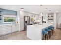 Modern kitchen with stainless steel appliances, white quartz countertops, and a stylish blue backsplash at 402 Saint Dunstan Way, Winter Park, FL 32792