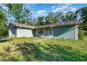 Side view of a single-story home with a grassy yard and a partial view of an attached garage at 468 E Oakwood Ave, Orange City, FL 32763