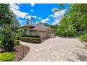 Side angle view of this well-maintained home featuring beautiful landscaping and a paved driveway at 5102 Round Tree Ct, Orlando, FL 32819