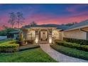 Well-maintained home featuring manicured landscaping, inviting front entrance, and exterior lighting at 5102 Round Tree Ct, Orlando, FL 32819
