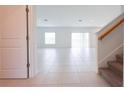 Open living room with white tile flooring, bright natural light, and sliding glass doors at 5345 Tuscany Ln, Davenport, FL 33897