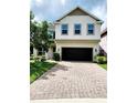 Charming two-story home featuring a manicured lawn, neutral paint, brick driveway, and a two-car garage at 813 Marsh Reed Dr, Winter Garden, FL 34787