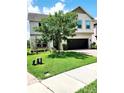 Well-maintained front yard of a two-story home with lush green grass and mature trees, and brick driveway at 813 Marsh Reed Dr, Winter Garden, FL 34787