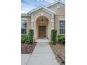 Elegant front entryway with a arched doorway and well-maintained landscaping at 9650 Bay Pine Ln, Orlando, FL 32832