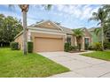Charming single-story home with a well-manicured lawn, mature palm trees and two-car garage at 9650 Bay Pine Ln, Orlando, FL 32832