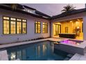 Gorgeous pool and jacuzzi area with a covered outdoor living space with a tv and grill at 10143 Mattraw Pl, Golden Oak, FL 32836
