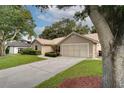 Exterior view of the house featuring a driveway, lawn, and mature trees at 1073 Sadie Ln, Winter Garden, FL 34787