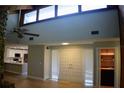 Spacious living room with vaulted ceilings, hardwood floors, and adjacent dry bar and white kitchen at 1102 Winter Springs Blvd, Winter Springs, FL 32708
