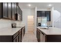 Modern kitchen featuring stainless steel appliances, a center island, and ample cabinet space at 14007 Picard Aly, Winter Garden, FL 34787