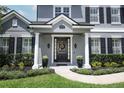 Inviting front entrance with decorative wreath, potted plants, and lush landscaping at 14252 Anastasia Ln, Orlando, FL 32828