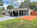 This home features a carport with extra parking space and a well-manicured lawn at 1428 Glendale St, Lakeland, FL 33803