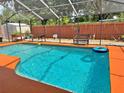 Enjoy this screened-in pool with patio seating and vibrant orange deck at 1428 Glendale St, Lakeland, FL 33803