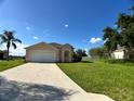 Single Gathering home with a driveway, well-manicured lawn, and blue sky at 1433 Bluff Loop, Dundee, FL 33838
