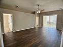 Spacious living room with wood flooring, ceiling fan, and sliding door to patio at 1433 Bluff Loop, Dundee, FL 33838