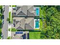 Aerial view of a community with a private pool, backyard, solar panels and lush green landscaping at 15343 Lebeau Loop, Winter Garden, FL 34787