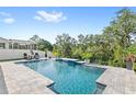 Relaxing backyard pool with waterfall feature, patio seating, manicured landscaping, and privacy fence at 15343 Lebeau Loop, Winter Garden, FL 34787