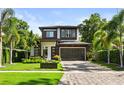 Two-story home boasts a well-manicured lawn, modern garage door, and meticulous landscaping at 1541 Chestnut Ave, Winter Park, FL 32789