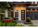 Charming front entrance with a modern door, stylish lighting, and lush landscaping at 1541 Chestnut Ave, Winter Park, FL 32789