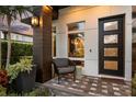 Inviting front porch with a modern door, stylish seating, and beautiful greenery at 1541 Chestnut Ave, Winter Park, FL 32789
