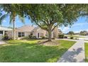 A single-story home with beautiful lawn and landscaping, plus a covered carport area and mature shade tree at 16602 Citrus Pkwy, Clermont, FL 34714