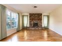 Cozy living room showcasing a brick fireplace, hardwood floors and natural lighting at 1746 Valley Forge Road, Orlando, FL 32806