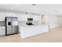 Modern kitchen featuring stainless steel appliances, white cabinets, and a spacious center island at 200 Garnet Ave, Kissimmee, FL 34758