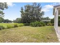 Expansive backyard with lush green grass and mature trees, great for outdoor activities at 25212 Ironwedge Dr, Sorrento, FL 32776