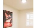 Bedroom with modern shutters, neutral walls, and vibrant tropical artwork at 2612 Summer Clouds Way, Kissimmee, FL 34744
