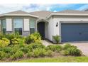Home exterior with a brick walkway, lush landscaping, and a two-car garage at 2612 Summer Clouds Way, Kissimmee, FL 34744