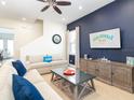 Bright living room with comfortable sofas, modern decor, and accent wall at 3004 Latitude Ln, Kissimmee, FL 34747