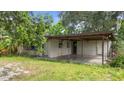 A home's covered carport is attached with a small amount of unkempt landscaping at 321 Beard Rd, Winter Garden, FL 34787
