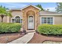 Inviting front entrance with stone archway and manicured landscaping at 335 Oakpark Loop, Davenport, FL 33837