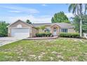 Charming single-story home features a stone-accented facade and a well-maintained lawn at 335 Oakpark Loop, Davenport, FL 33837
