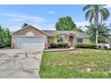 Charming single-story home features a stone-accented facade and a well-maintained lawn at 335 Oakpark Loop, Davenport, FL 33837