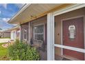 Inviting screened front porch with bench seating and a charming front door at 37 Pecan Pass Trl, Ocala, FL 34472