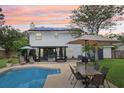 Spacious backyard with pool, patio, outdoor seating, lush greenery, and solar panels at 4536 Misty Morn Cir, Orlando, FL 32812