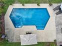 Aerial view of the backyard swimming pool with lounge chairs and an umbrella at 4536 Misty Morn Cir, Orlando, FL 32812