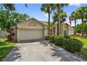 A single-story home featuring a driveway and lush, green landscaping at 5704 Bay Side Dr, Orlando, FL 32819