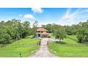 Expansive aerial view of a two-story home on a large lot featuring mature trees and a gated entrance at 6346 Dallas Blvd, Orlando, FL 32833