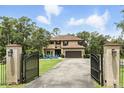 Stately two-story home featuring a gated entrance, a long driveway and a cozy seating area with rocking chairs at 6346 Dallas Blvd, Orlando, FL 32833